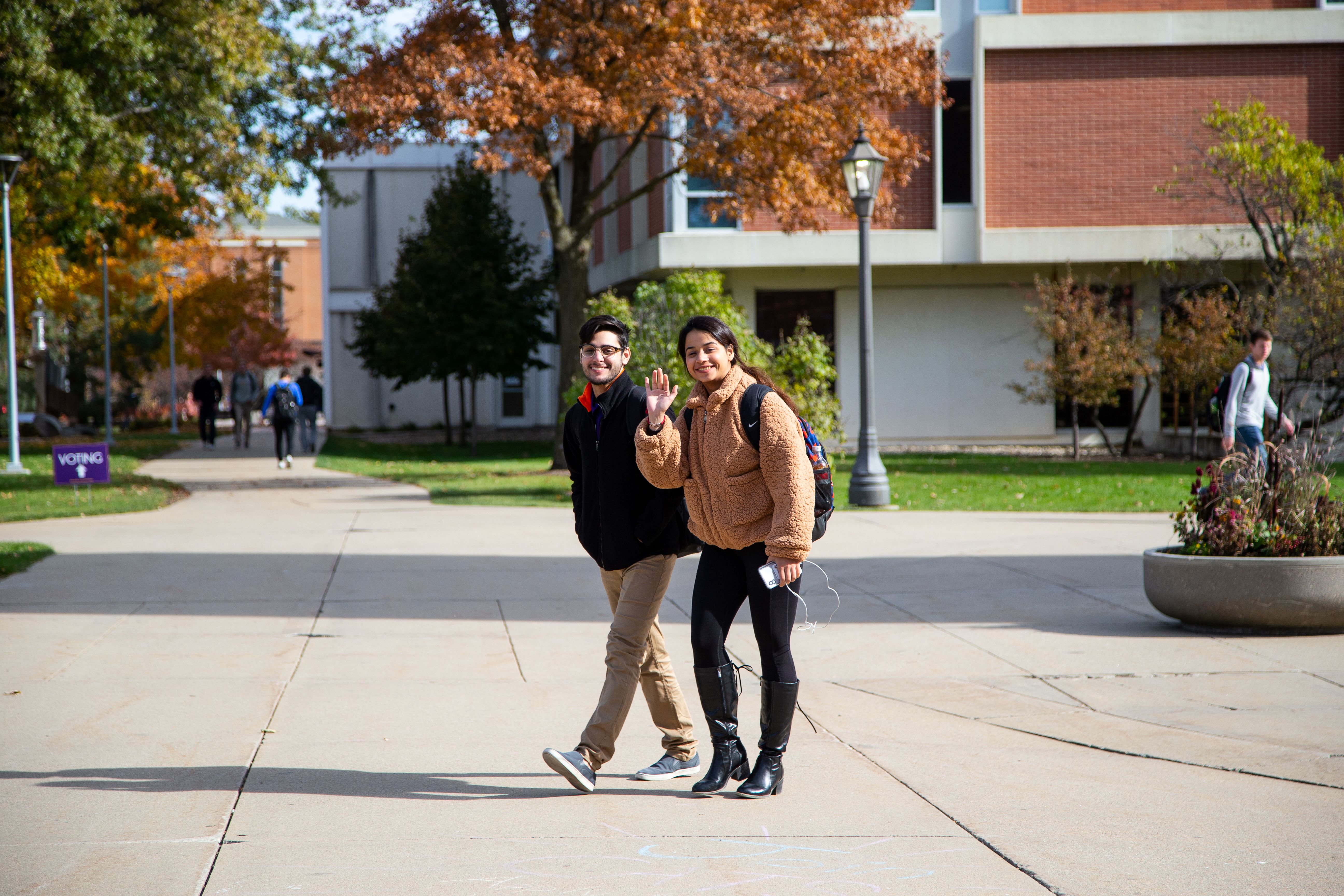Two students walking in front of Rod Library in Fall.